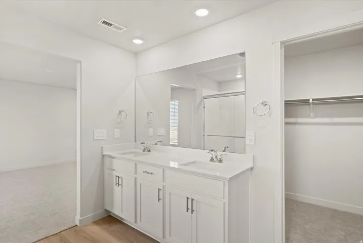 White double vanity featuring dual sinks and chrome faucets