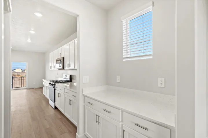 Kitchen featuring white cabinetry, stainless steel appliances, and a gas range