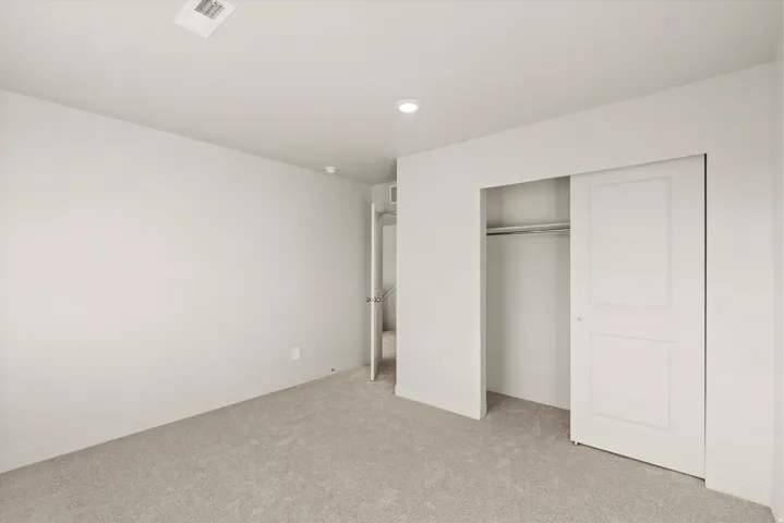 Carpeted room with recessed lighting and a sliding closet door