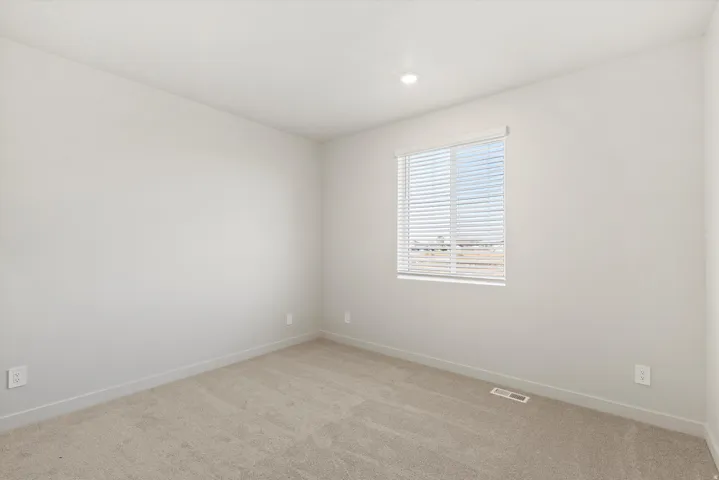 Bright interior space with light neutral wall paint and plush carpet flooring
