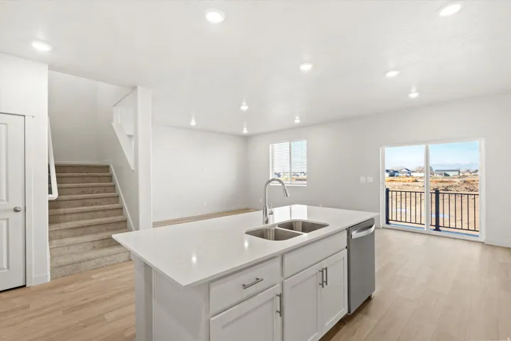 Kitchen island with a dual-basin stainless steel sink, chrome faucet, and integrated dishwasher