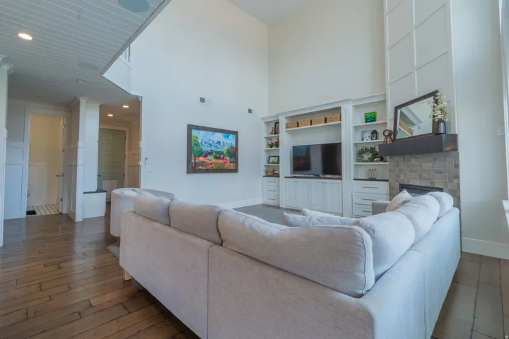 Spacious living area featuring high ceilings, wood-finish flooring, and wainscoting details