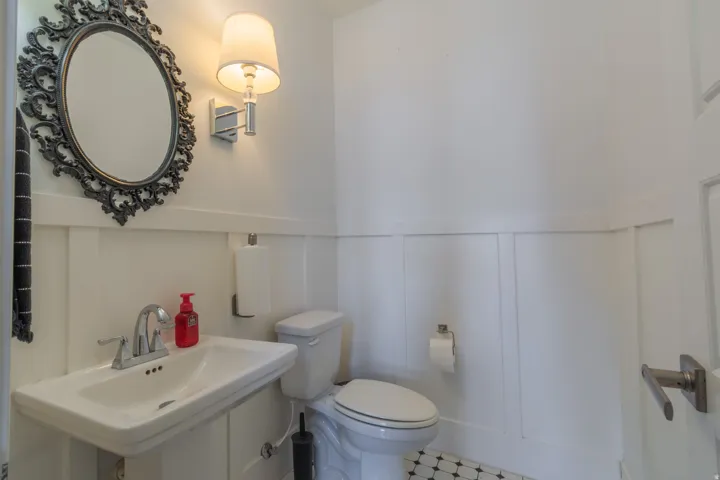 White board and batten wainscoting paneling with a pedestal sink featuring a chrome faucet