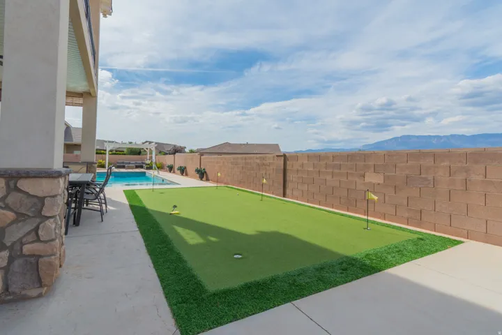 Expansive outdoor area featuring a built-in putting green, a swimming pool, and an outdoor patio with a pergola