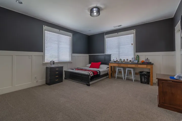 Carpeted room featuring board and batten wainscoting with dark accent walls