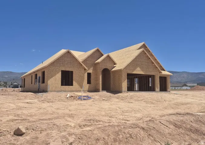 New construction home with a multi-gabled roofline and attached two-car garage framing