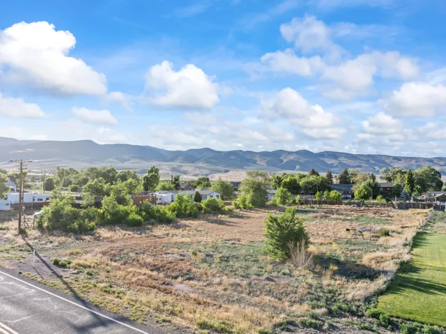 Expansive land parcel featuring natural vegetation and distant mountain ranges