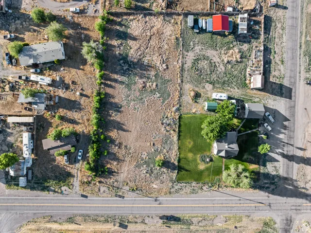 Expansive property featuring a mix of cleared land and a building with a red roof