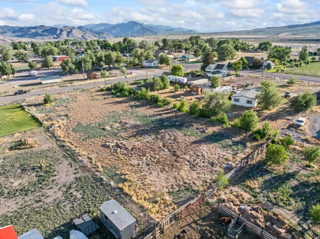 Expansive undeveloped land parcel featuring natural terrain and distant mountainous backdrop