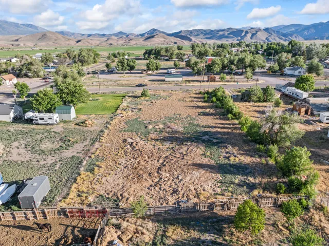Expansive land parcel with partial fencing and established trees