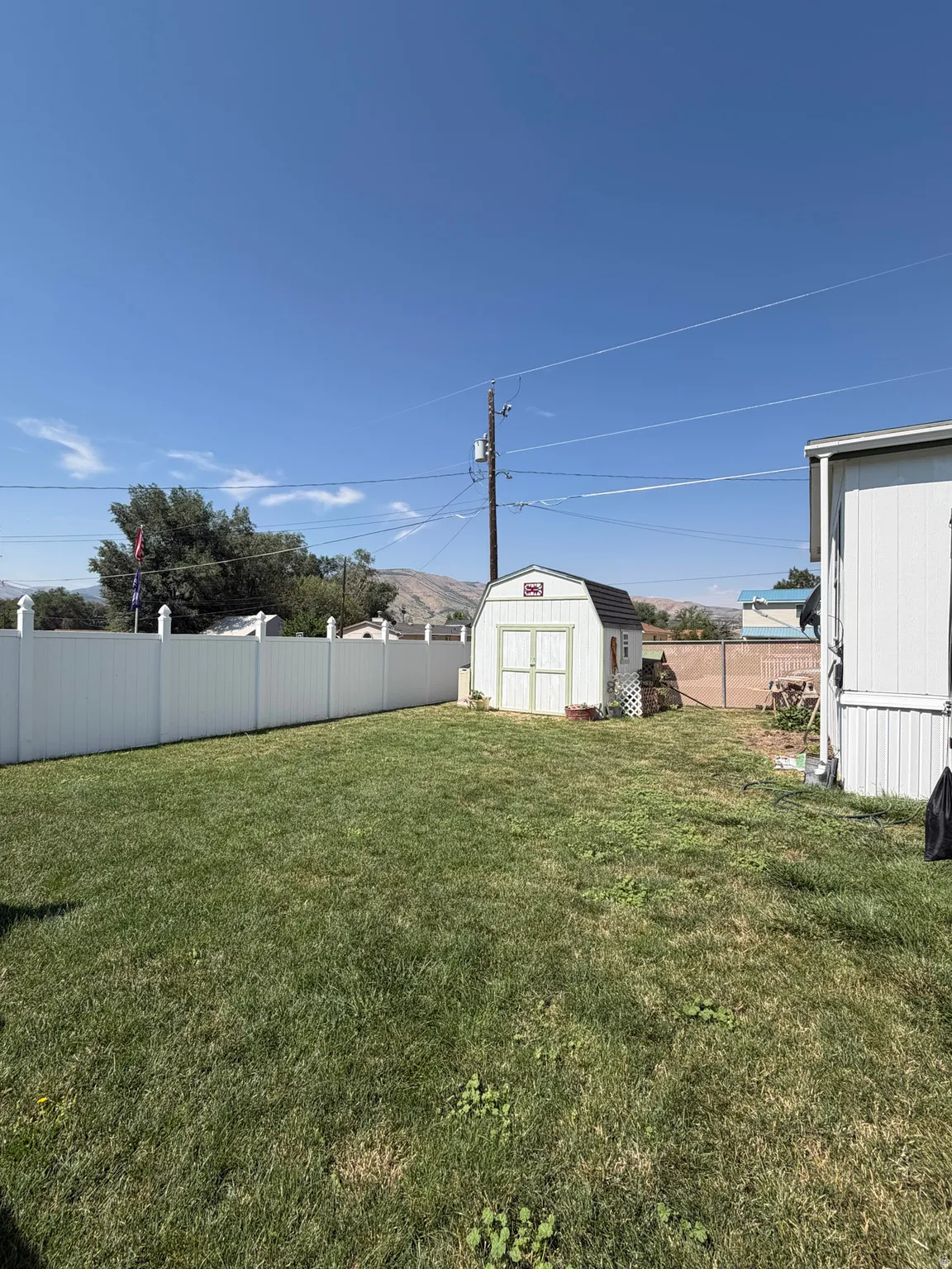 Expansive green lawn surrounded by a white privacy fence