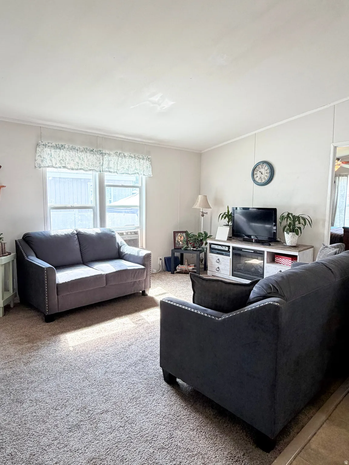 Living area featuring light-colored walls and carpet flooring