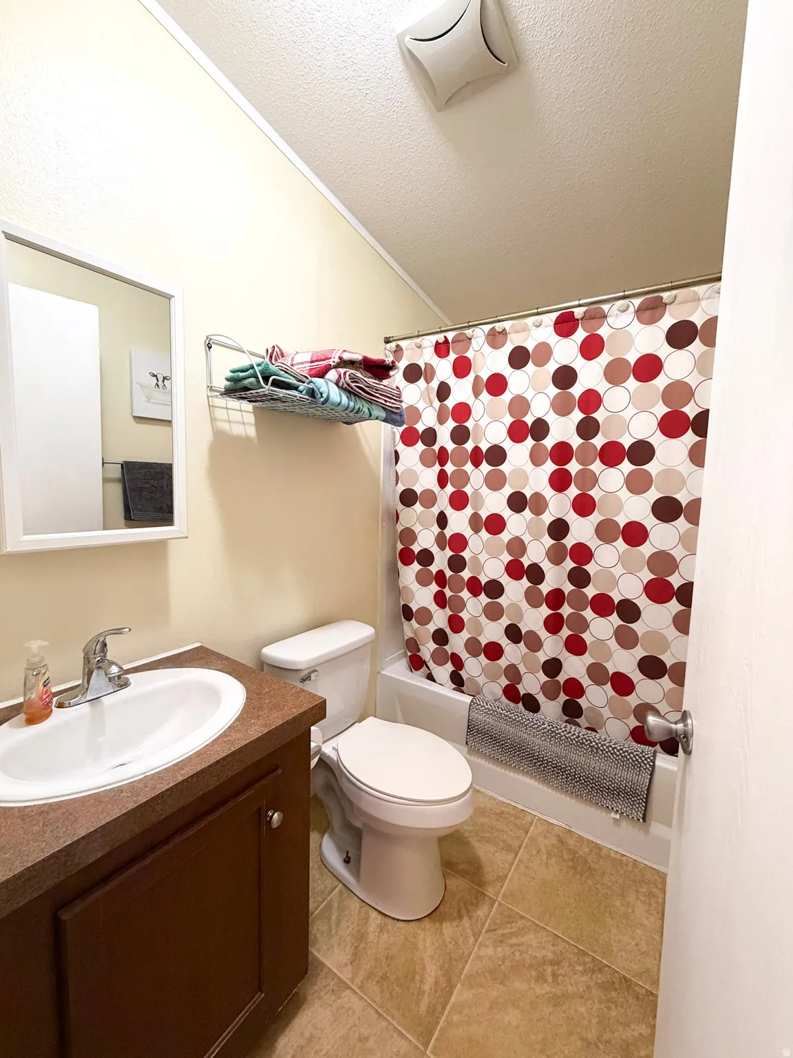 Neutral-toned bathroom featuring a dark wood-finish vanity with an integrated sink and chrome faucet