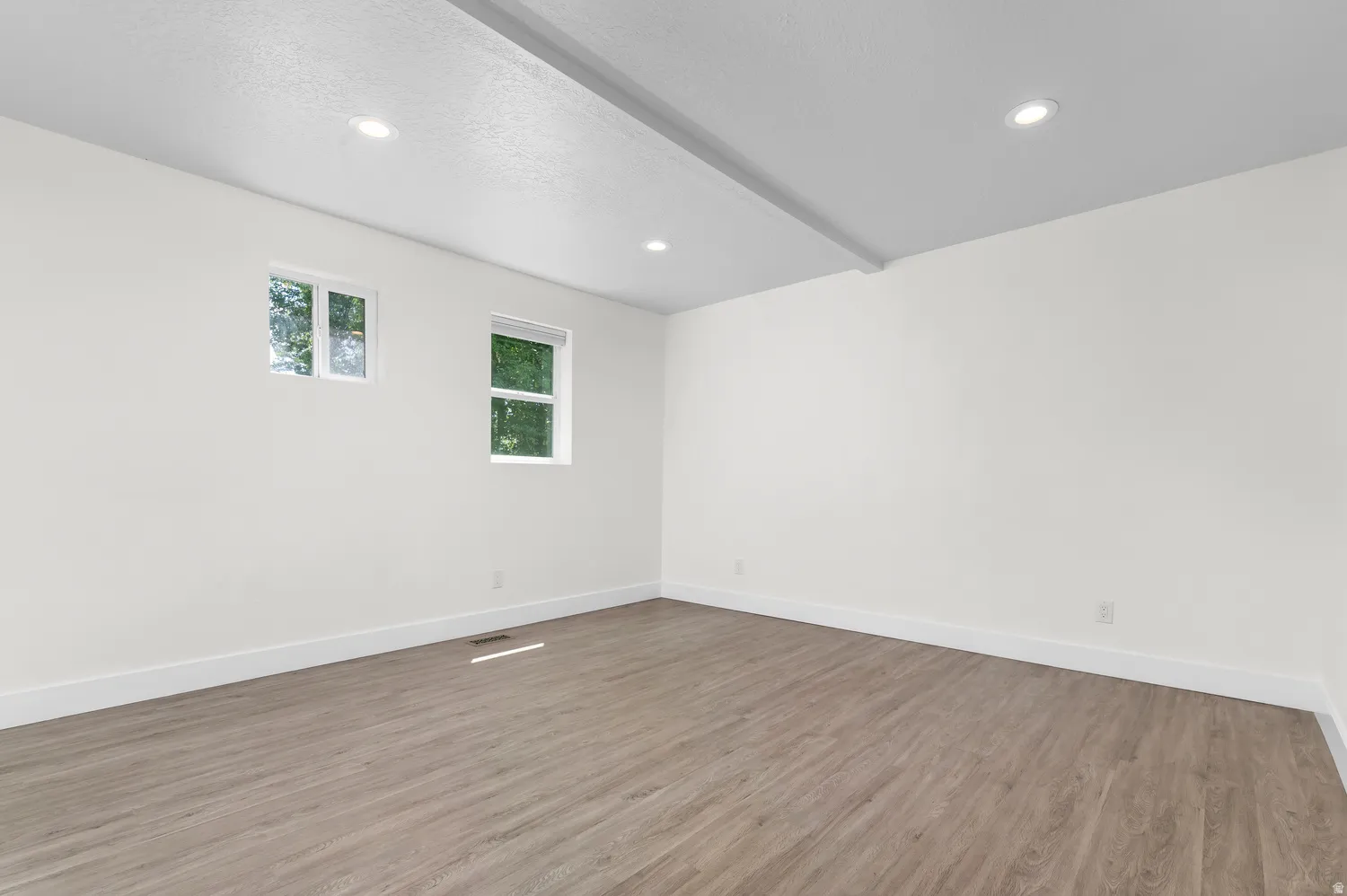 Bright interior space featuring wood-finish flooring, white walls, and recessed lighting