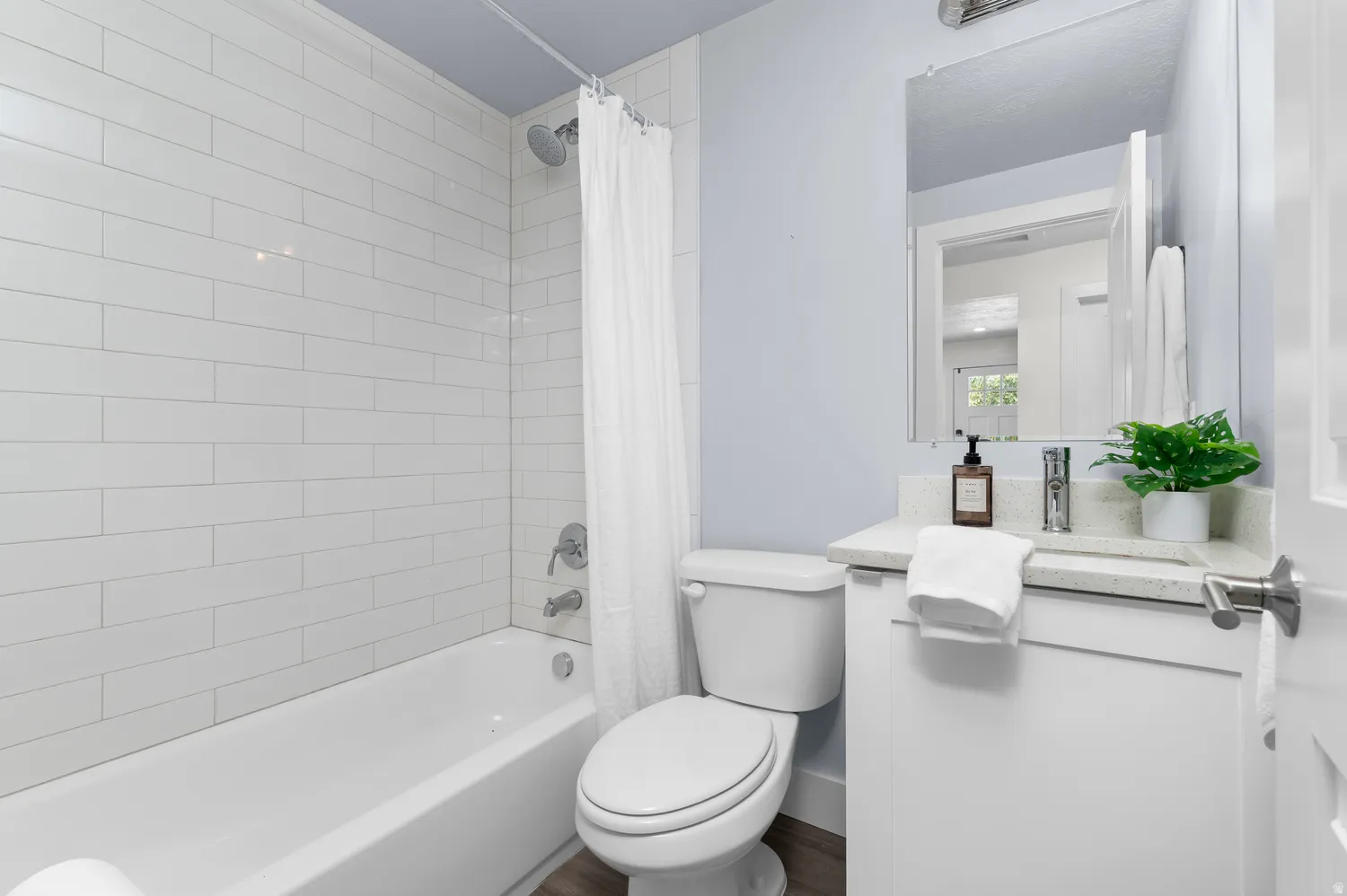 Bathroom featuring a white subway tile shower surround with a chrome shower head and faucet