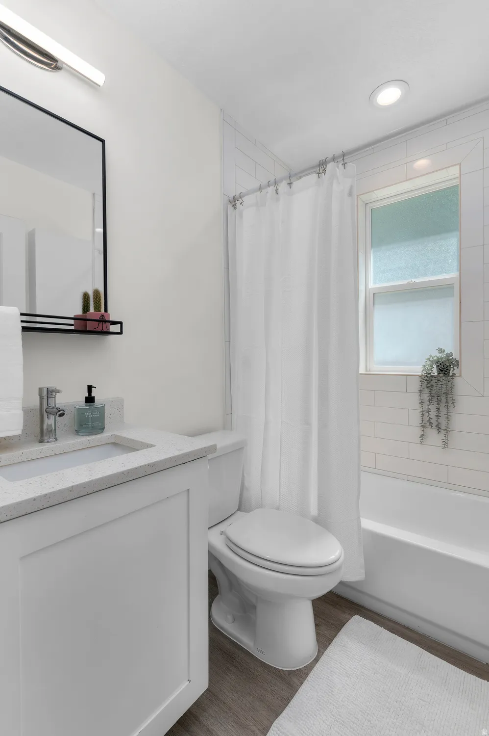 Bathroom featuring a white vanity with a light-toned countertop, a rectangular undermount sink, and chrome fixtures