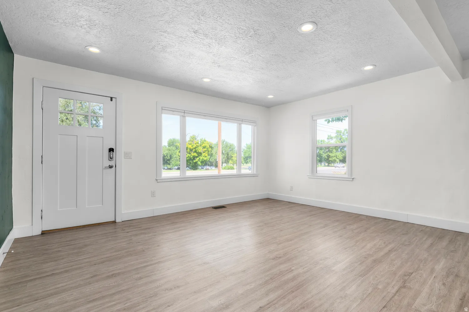 Spacious interior featuring wood-finish flooring, white walls, and recessed lighting