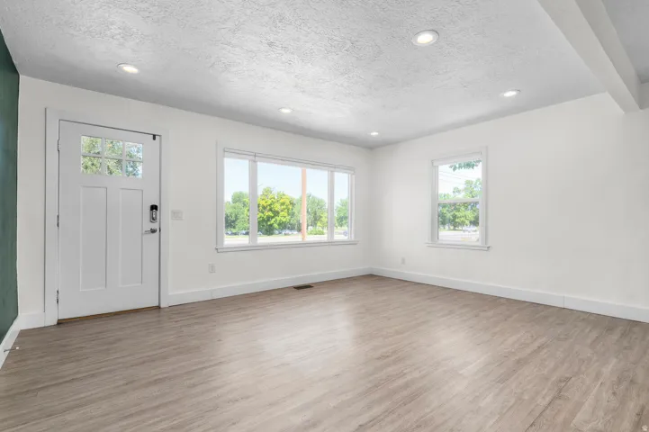 Spacious interior featuring wood-finish flooring, white walls, and recessed lighting