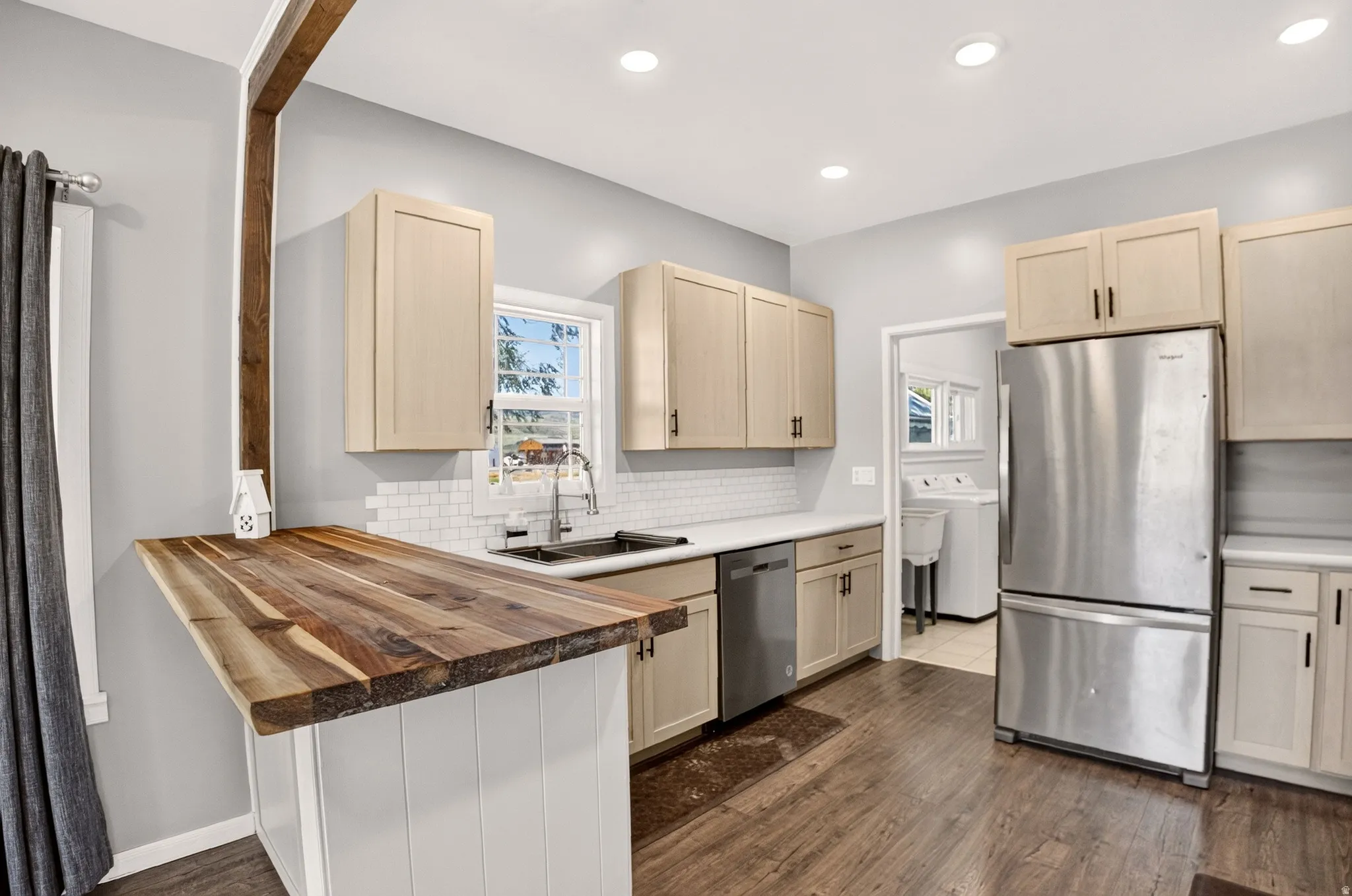 Kitchen featuring wood-finish flooring, recessed lighting, and a butcher block breakfast bar with a support beam