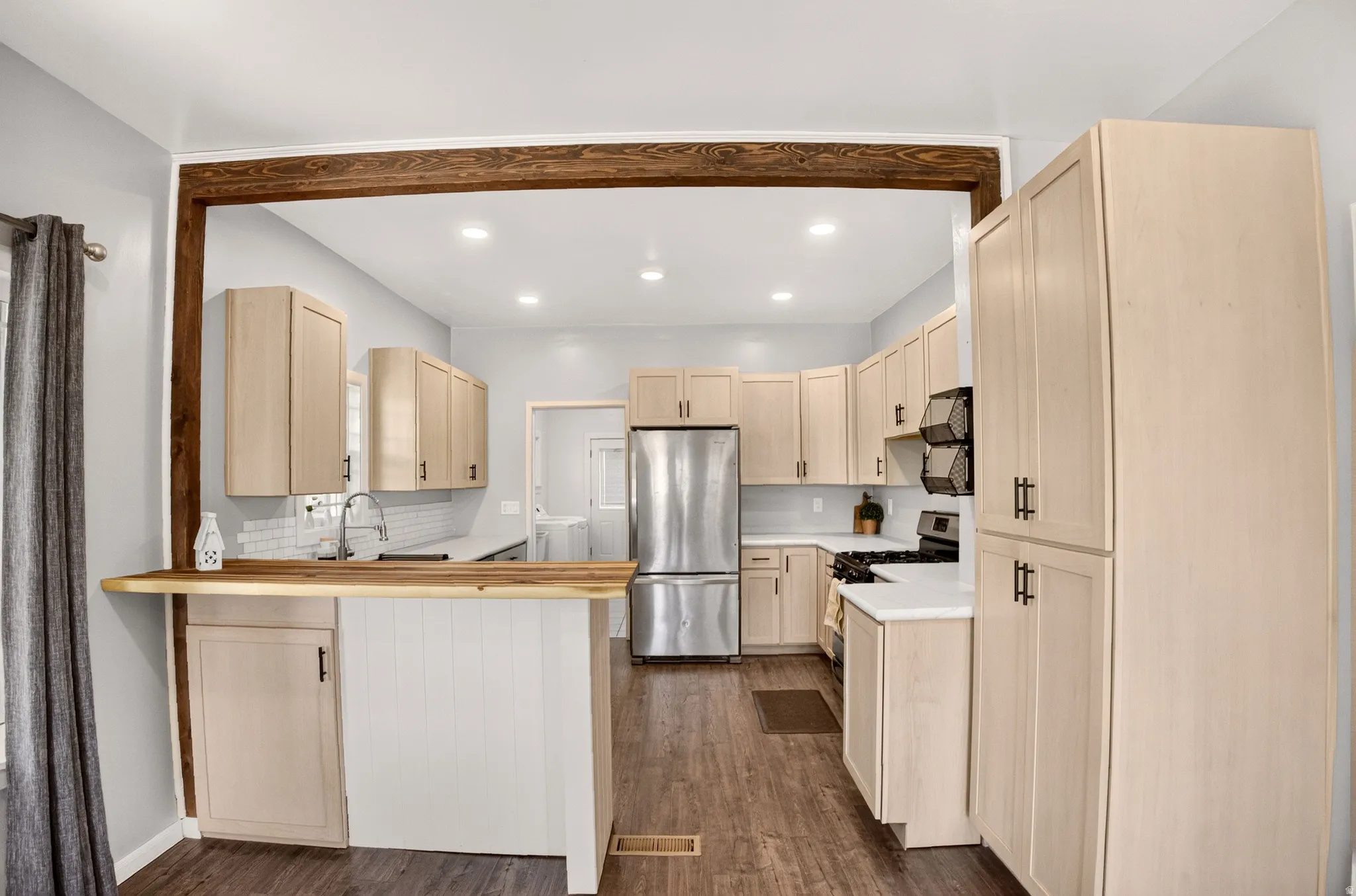 Kitchen featuring wood-finish flooring and light-toned cabinetry