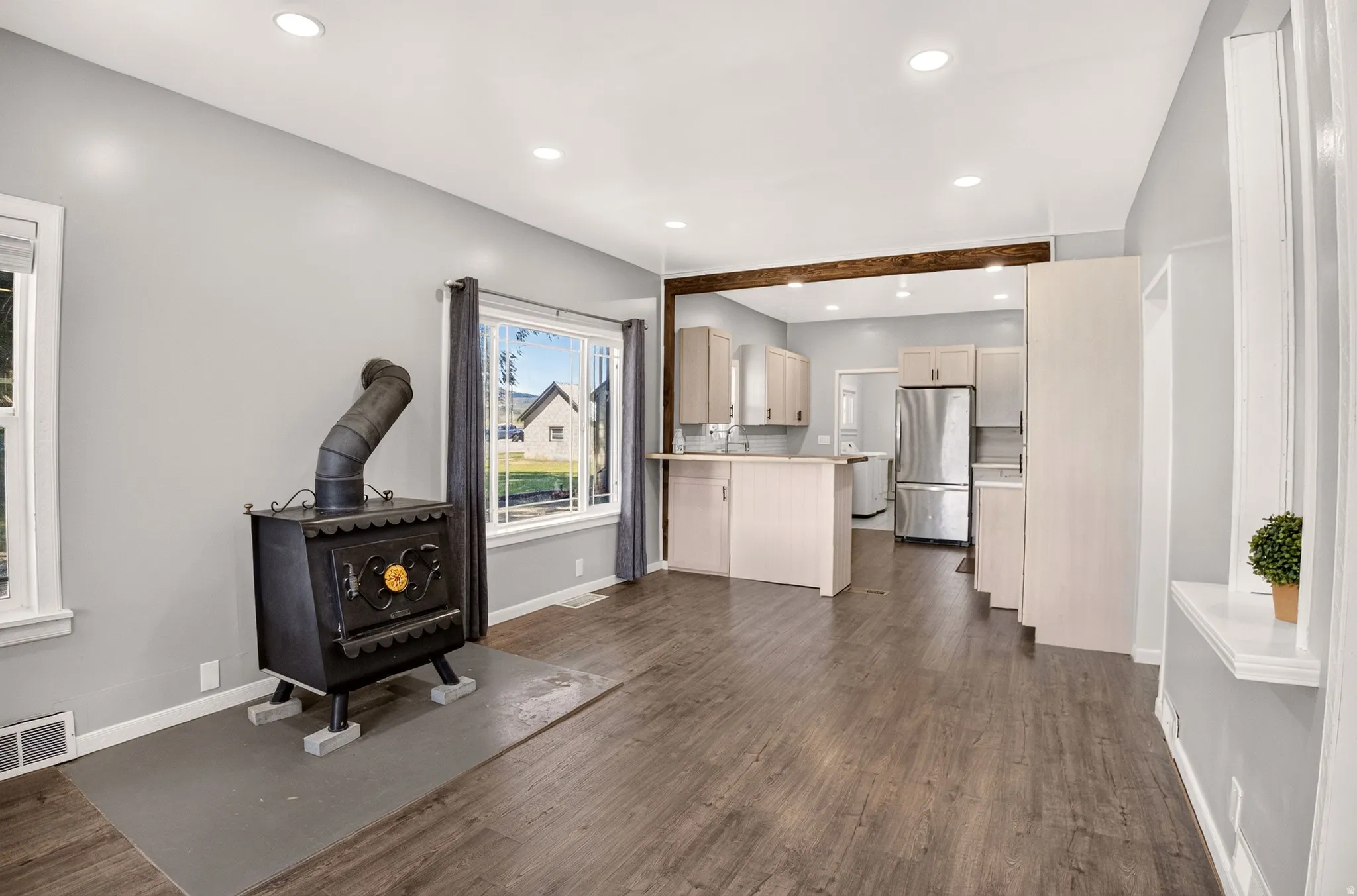 Open-concept living area featuring wood-finish flooring, recessed lighting, and light grey wall tones