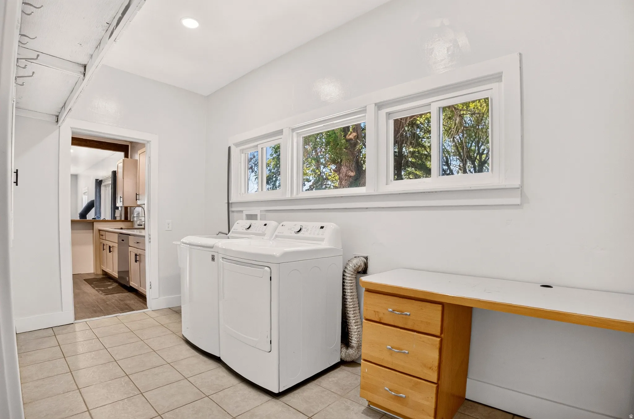 Dedicated utility area featuring a tiled floor, white walls, and a row of three transom windows