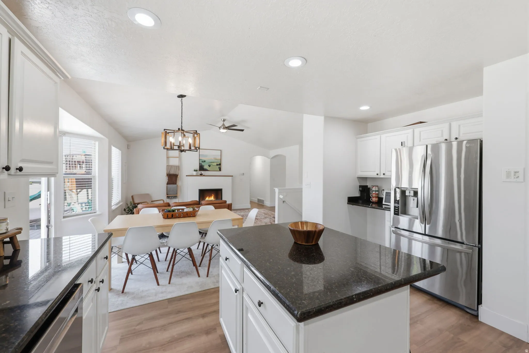 Kitchen featuring white cabinetry, dark countertops, stainless steel appliances, and wood-finish flooring