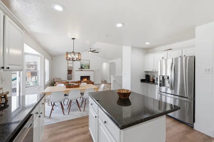Kitchen featuring white cabinetry, dark countertops, stainless steel appliances, and wood-finish flooring