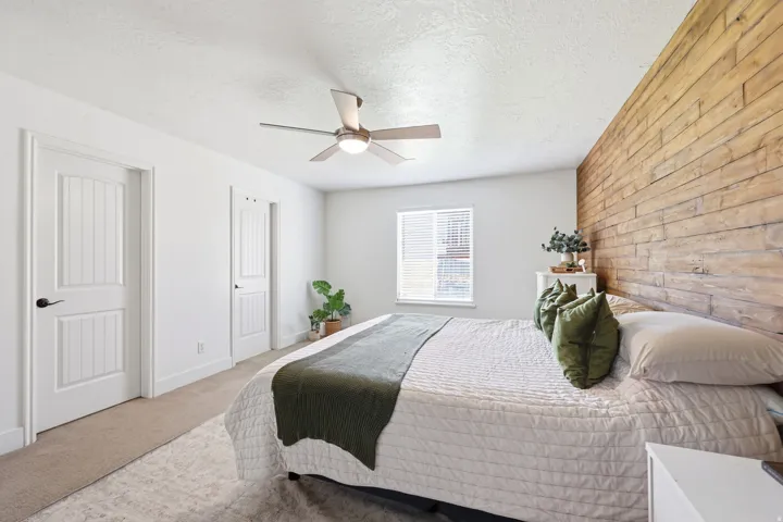 Accent wall featuring horizontal wood paneling, white walls, and light-colored carpet