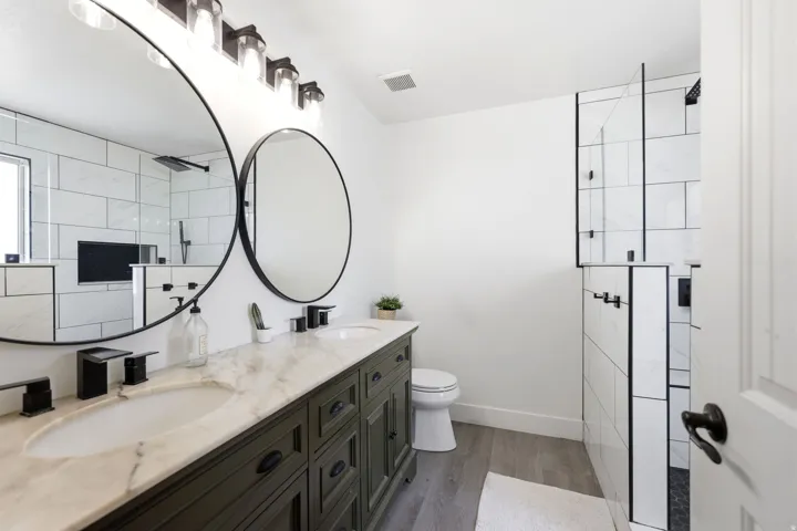 Dual vanity with a stone countertop, undermount sinks, and matte black fixtures