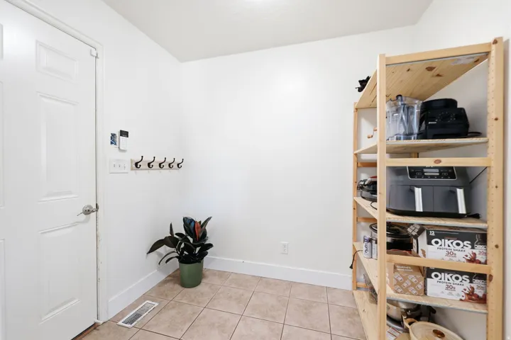 Entryway featuring light-toned tile flooring, a white panel door, and white baseboards