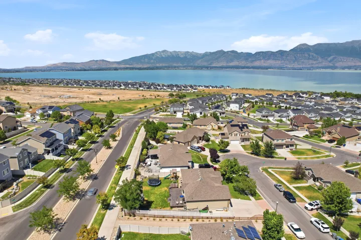 Aerial overview of a residential neighborhood featuring homes with varied architectural styles, mature landscaping, and an organized street grid