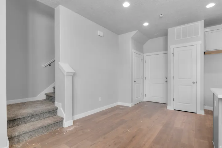 Wood-finish flooring, recessed lighting, and white interior doors