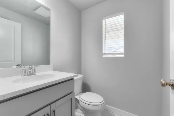 Single vanity with an integrated sink, polished chrome faucet, and light-toned countertop