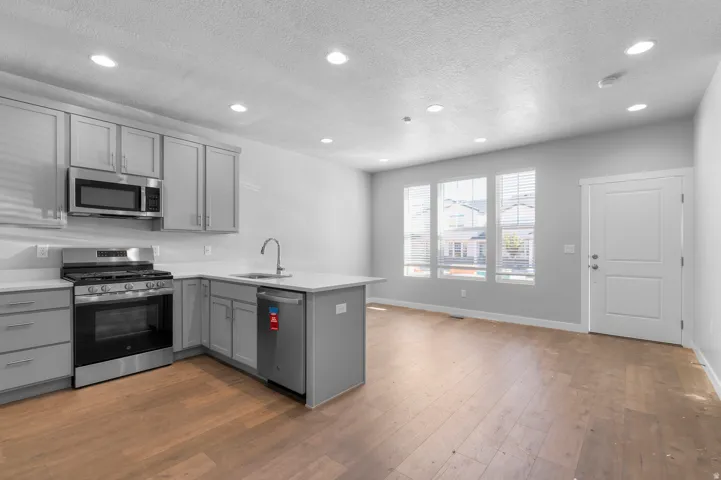 Kitchen featuring stainless steel appliances, light gray cabinetry, and light countertops