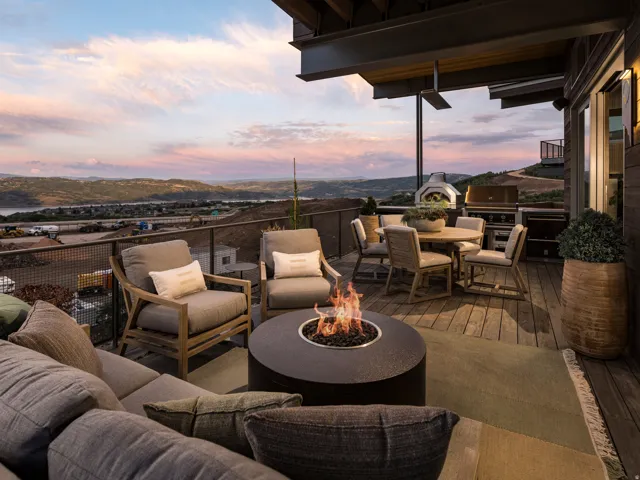 Expansive outdoor deck featuring wood-finish decking, a built-in fire pit, and an integrated outdoor kitchen