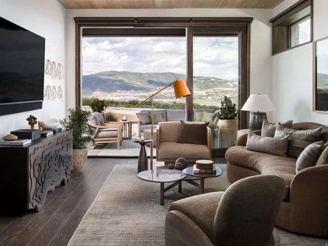 Sliding glass doors open to an outdoor space with mountain scenery