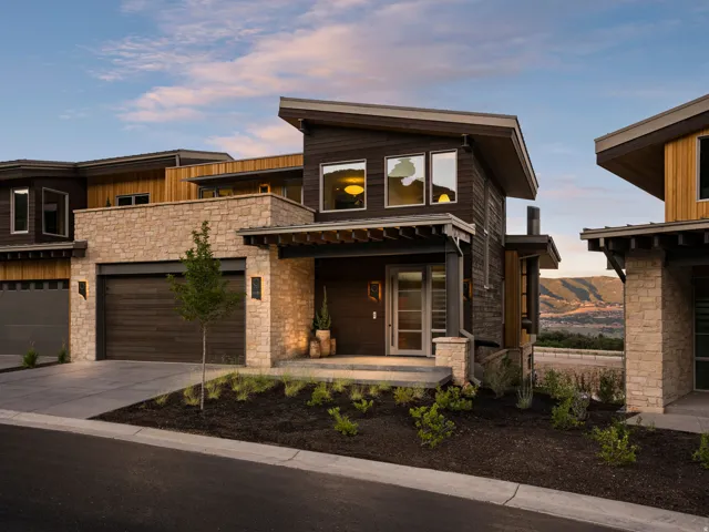 Contemporary multi-level exterior showcasing varied textures including stone veneer, dark wood siding, and light wood accents
