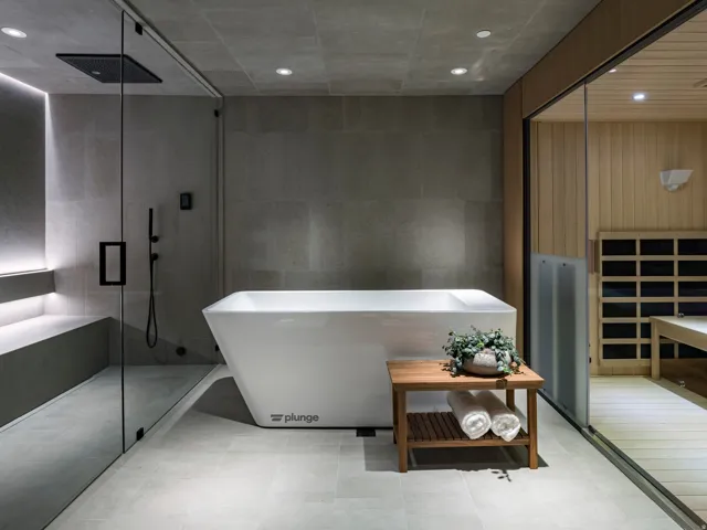Luxurious spa-inspired bathroom featuring a freestanding soaking tub, a spacious glass-enclosed shower with a bench, a rain showerhead, and recessed lighting