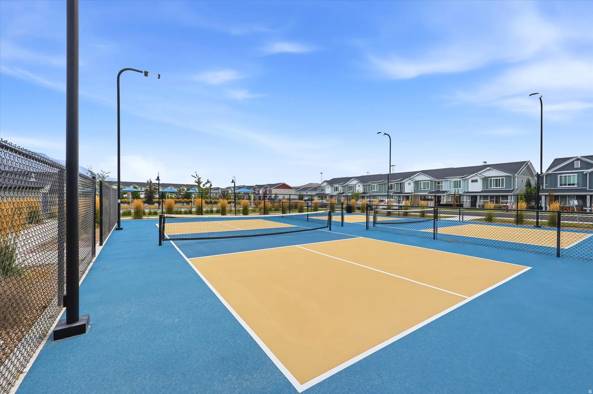 Multiple pickleball courts with blue and tan surfacing