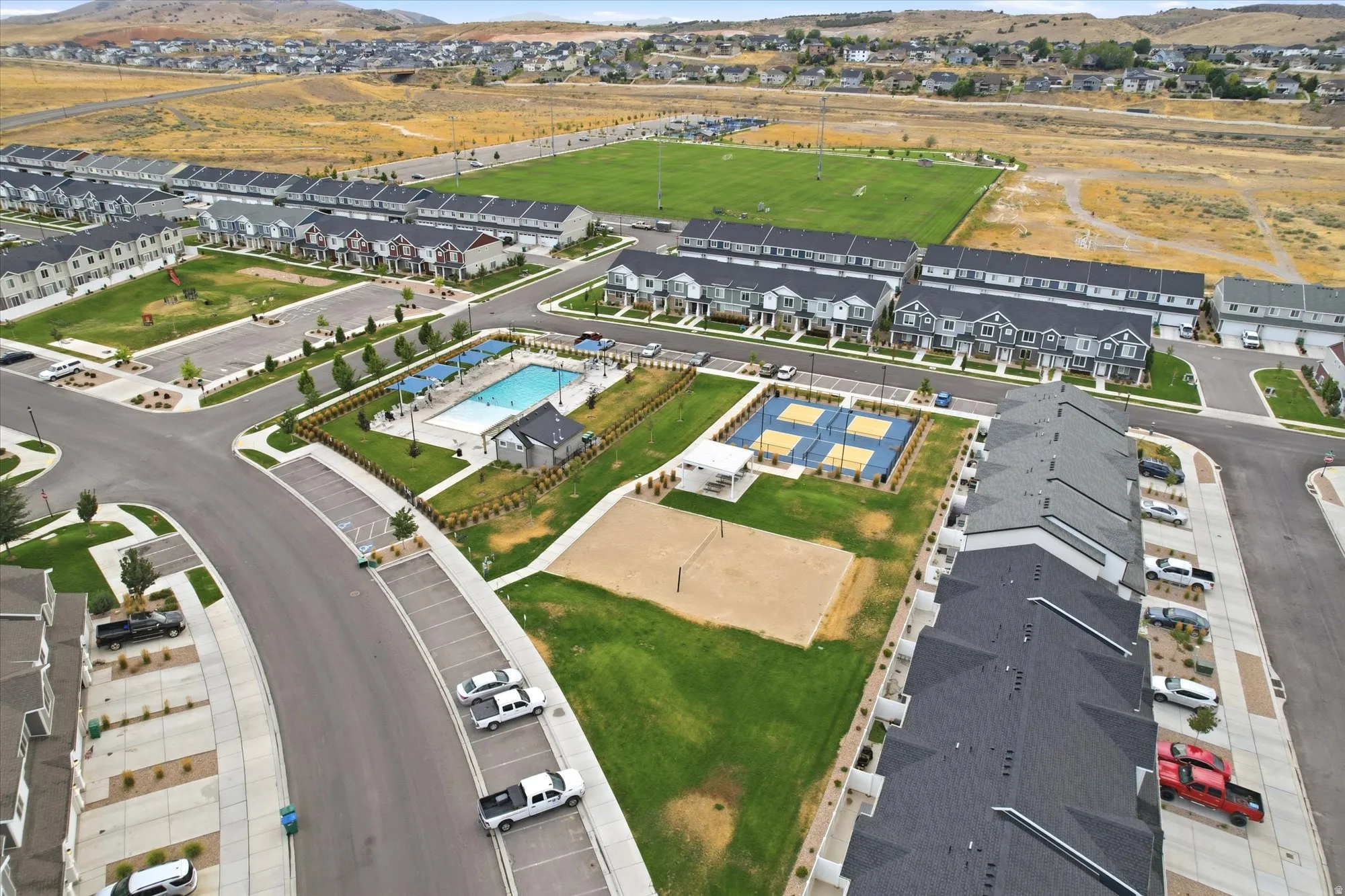 Community amenities featuring a swimming pool, multiple sports courts, volley ball and a park