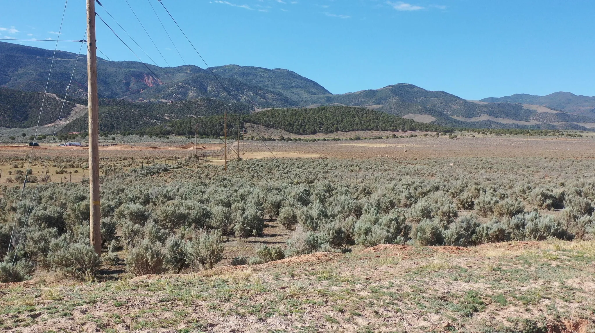 Expansive undeveloped land featuring natural shrubbery and distant mountains