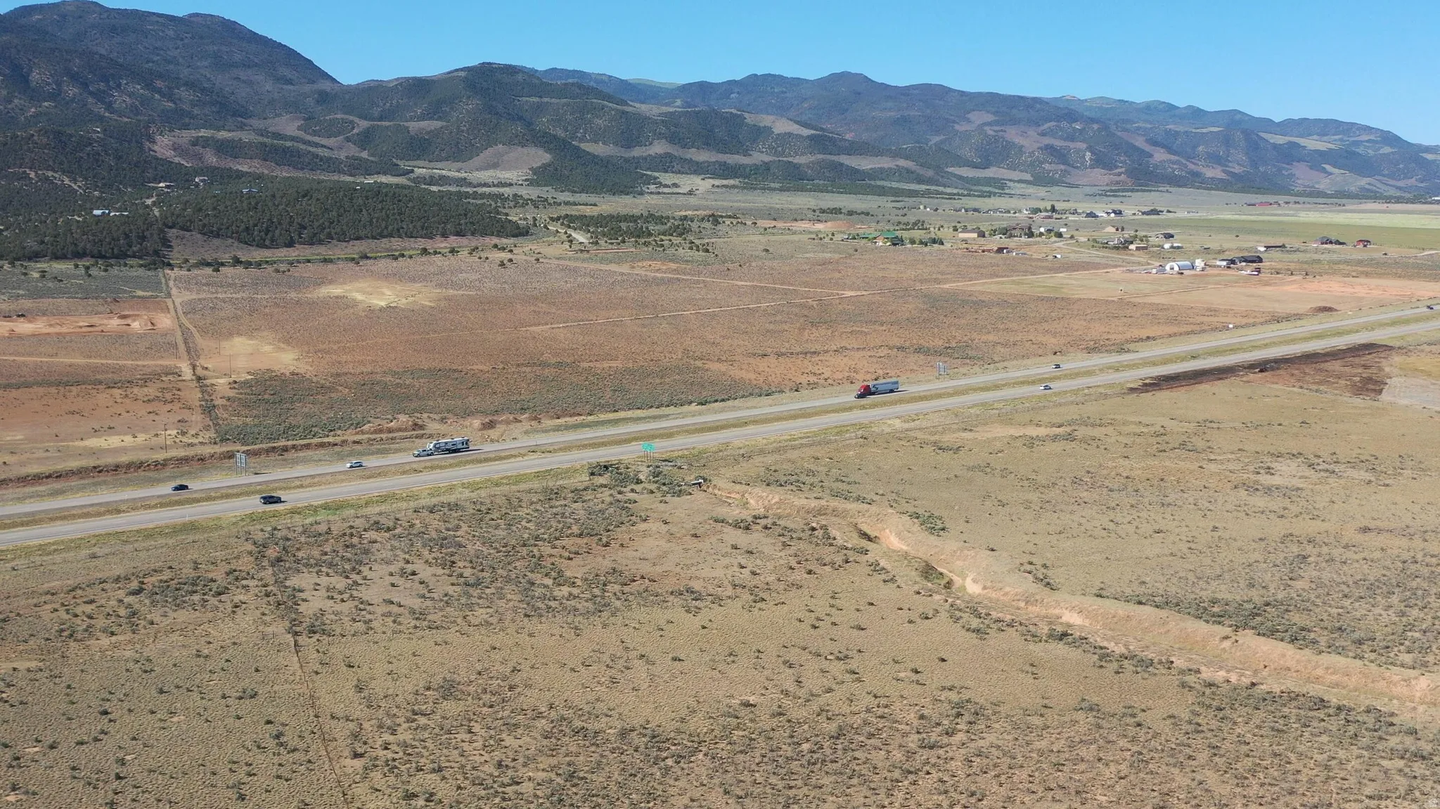 Expansive land parcel featuring direct highway frontage and mountain backdrops