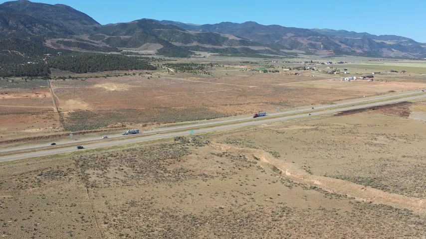 Expansive land parcel featuring direct highway frontage and mountain backdrops