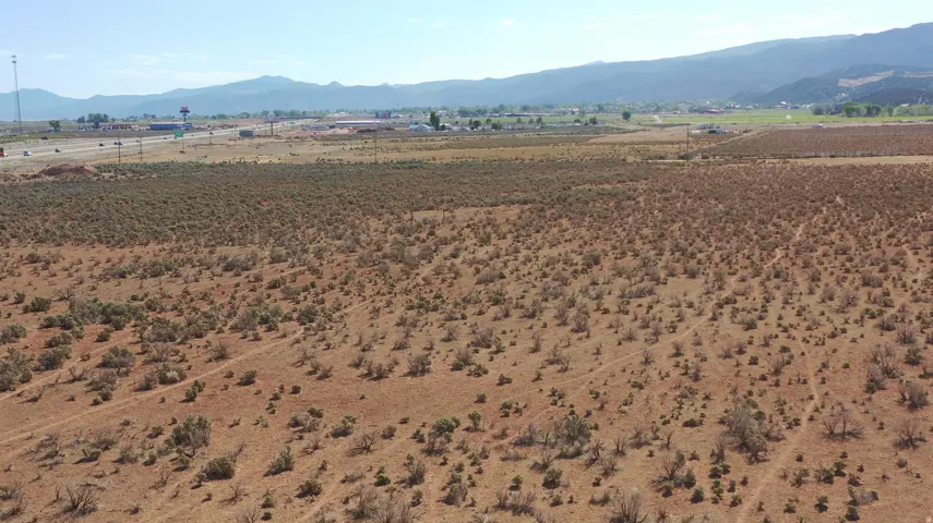 Expansive undeveloped land with natural scrub brush and distant mountain ranges