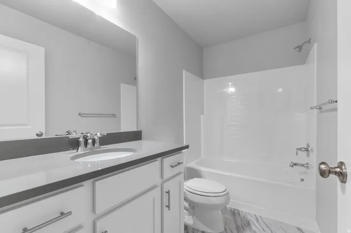 White vanity with a light-toned countertop and an undermount sink
