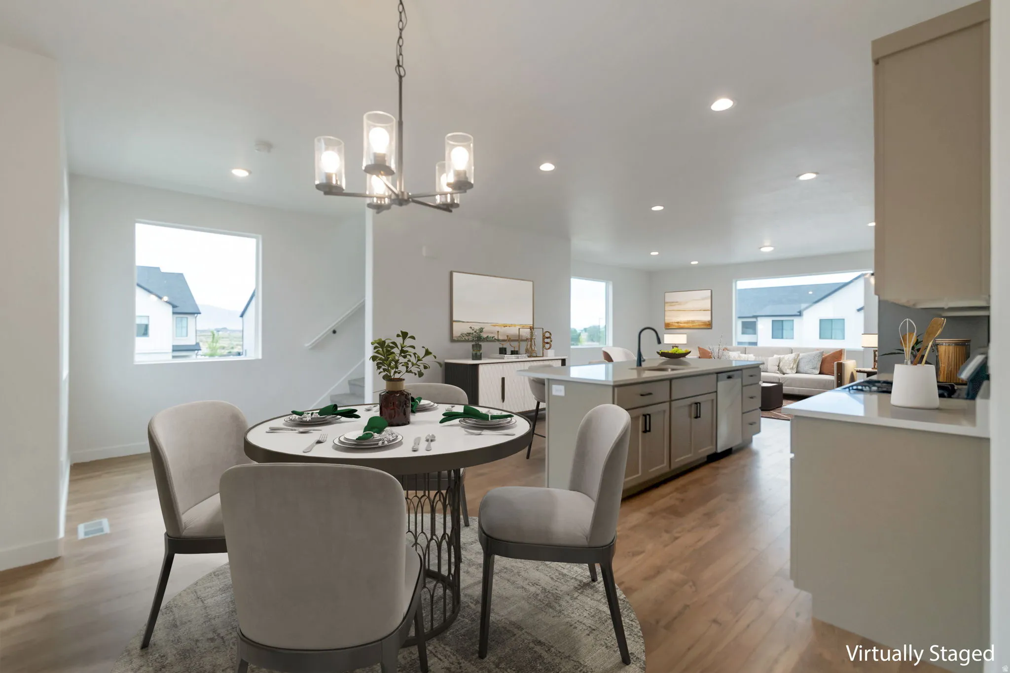Open-concept living space with wood-finish flooring, recessed lighting, and a modern chandelier