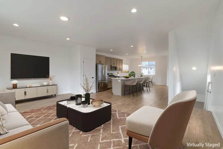 Open-concept living area featuring wood-finish flooring, recessed lighting, and a neutral color palette