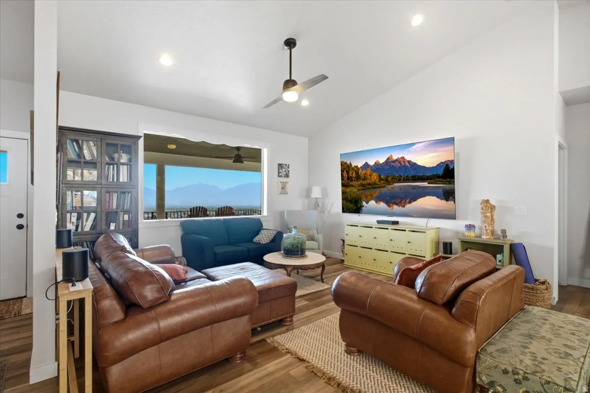 Vaulted ceilings accent the main living space with recessed lighting and a ceiling fan