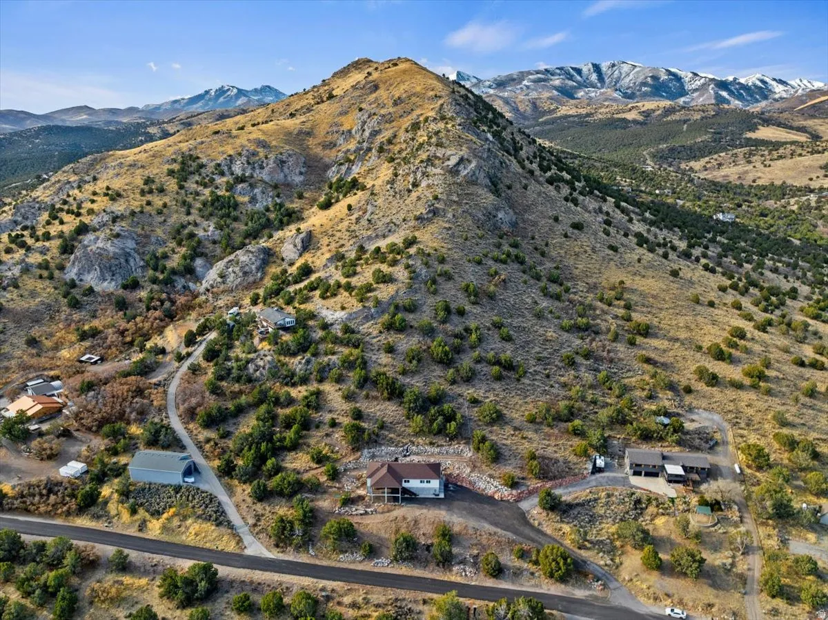 Property situated on a sloped, natural landscape with a prominent mountain backdrop